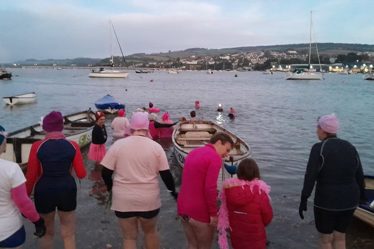 Teignmouth Mermaids dressed in pink enter the River Teign as the moon sets