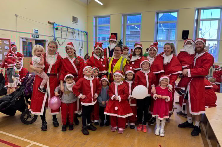 Evie Compton with some of the Santas who took part in the Santa Dash. AQ 9050