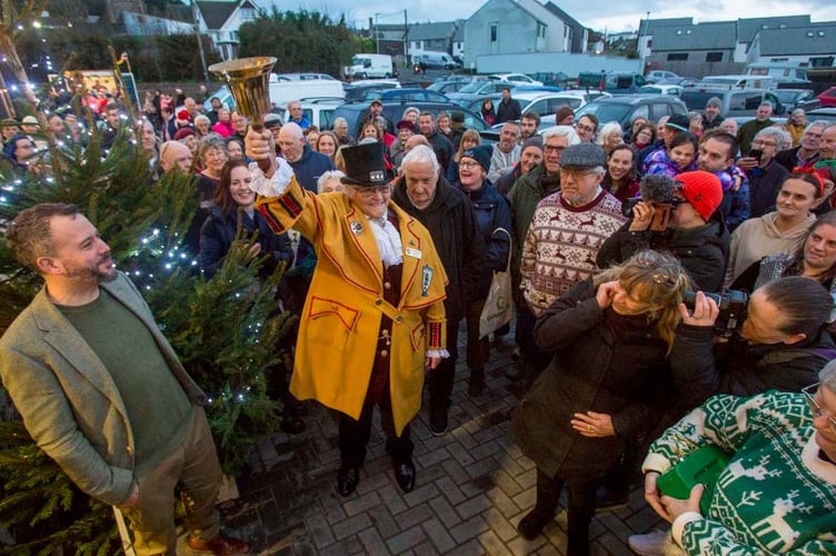 Town crier Ros Chard rings her bell to announce the opening of the market