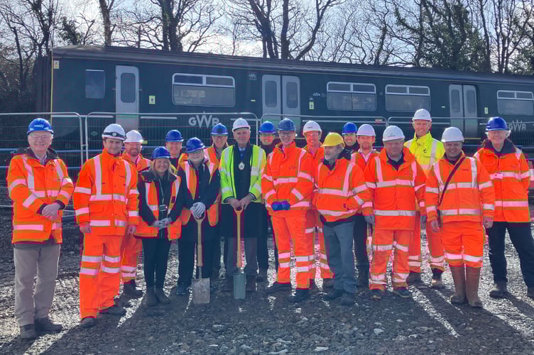 Those gathered for the turf cutting at the Okehampton Interchange, Dartmoor Line train passing in the background