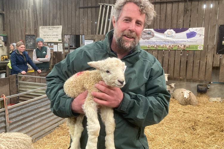 Farmer Mat Cole with a young lamb