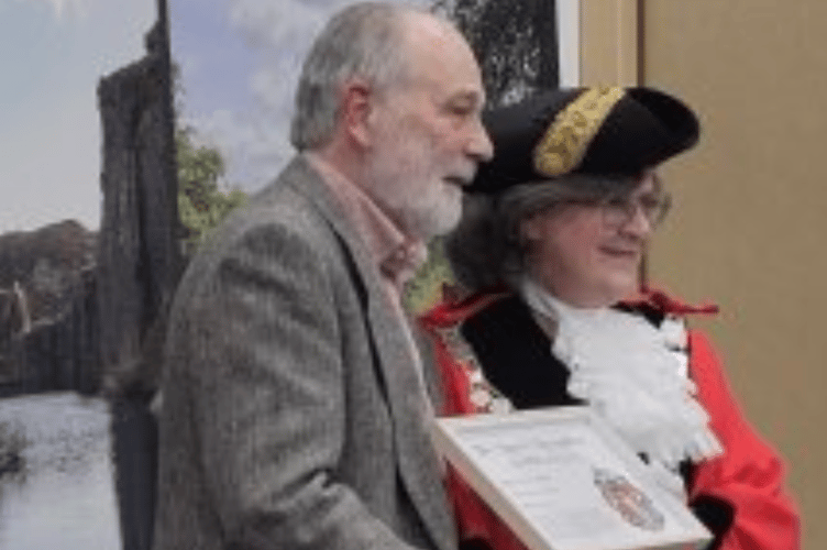Mike Watson receiving the award on March 22.