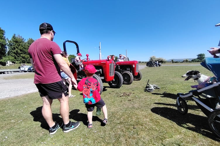 Yelverton Family Fun day and tractor un Little boys entranced by bug-eyed red tractor.