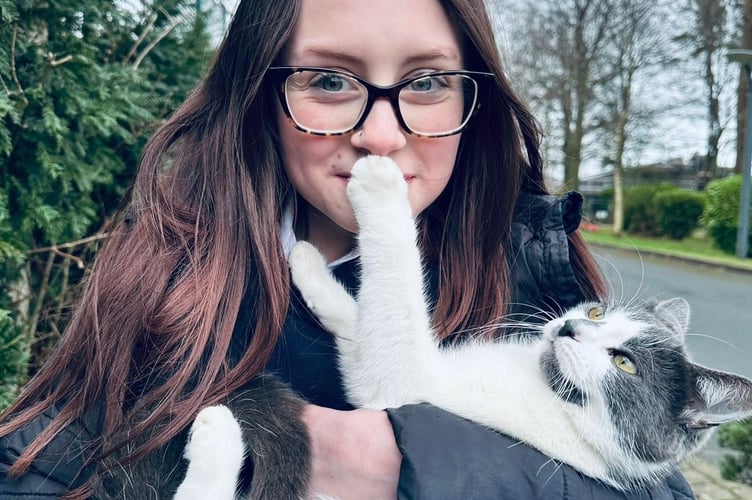 Dusty the cat with one of her humans back home on the Isle of Man.