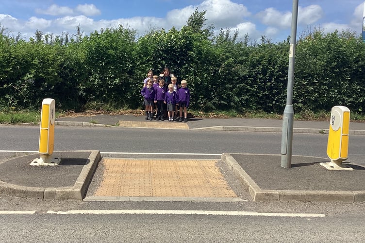 The children with their headteacher on the crossing which will soon have a 'patrol officer' to see the children over busy Crediton Road.