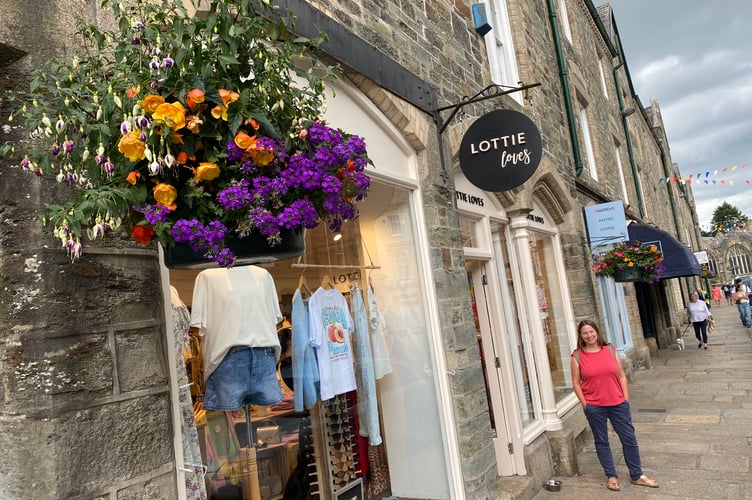 Lottie Loves is watering its floral hanging baskets.
