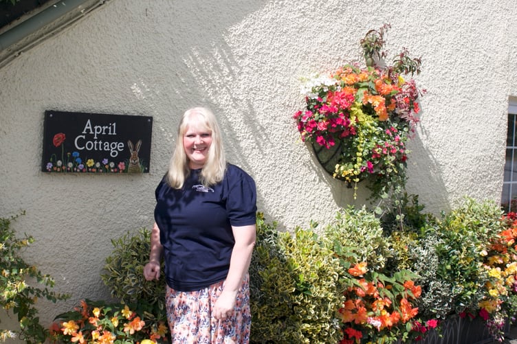Green-fingered Claire White outside her much-admired floral home in Lamerton. Picture by Jude Wright.