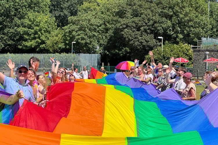 Holding the giant rainbow flag at Okehampton Pride.  AQ 6510
