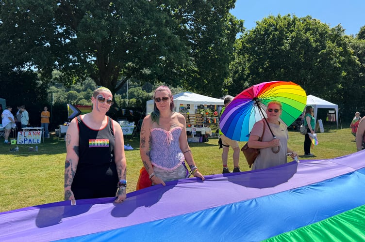 Holding the giant rainbow flag at Okehampton Pride.  AQ 6519
