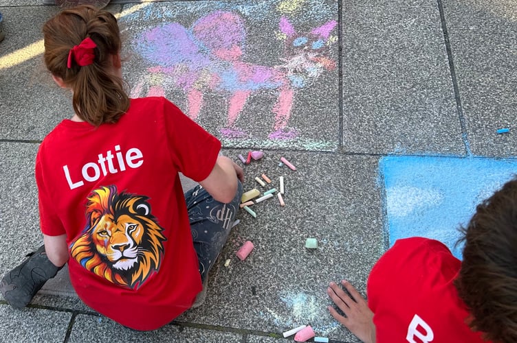 Hard at work on their creations in the Lions' carnival pavement art competition.