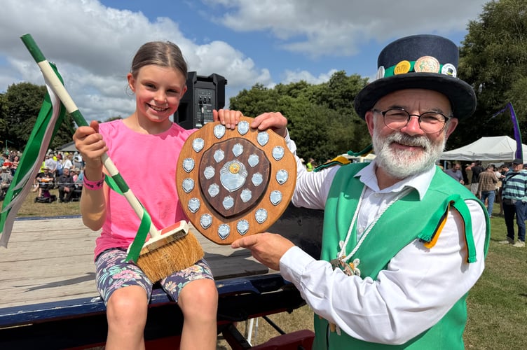 Ella Stephenson (10) of Woodcote, near Oxford, was the winner of the 2025 Dartmoor Broom Dance competition. She was presented with her trophy by Exeter Morris Squire Dave Minty. AQ 9051