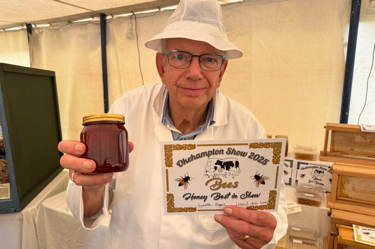 National Honey Judge Jack Mummery of West Buckland with the Best in Show Honey which was exhibited by Lynette Rogers from Okehampton. AQ 9975