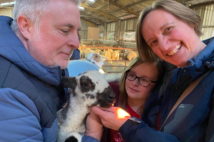 A new lamb brings smiles to a family at Greenwell Farm's lambing open day at Meavy.