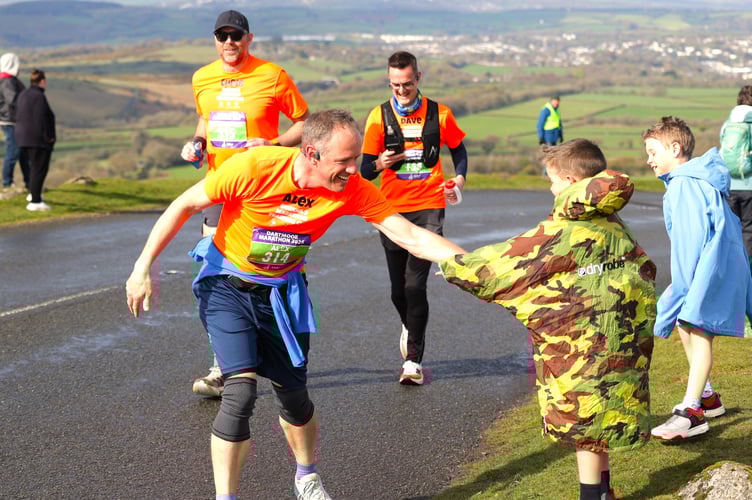 A welcome energy treat is grabbed without a break by a runner on his way to Princetown above Tavistock on the Dartmoor Marathon which returned on Sunday, April 12, after a 40-year absence. Picture by Chris Cottrell.