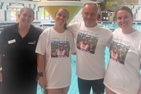 Widower Will Crosby celebrates finishing his epic 850-mile swim in Tavistock in tribute to his late wife Harriet with their daughters (right) Thea and Rosie who swam the final mile with him.