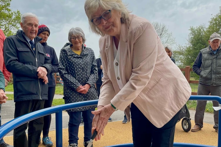 Sue Hicks cutting the ceremonial roundabout opening cake at Yelverton Play Park.