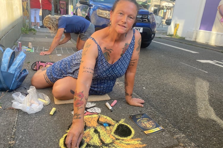 Helen Bowyer chalks her glowing lion as part of a chalk gallery of pictures on Tavistock high street for the Lions Carnival Week pavement art competition.