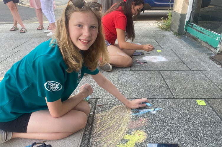 Georgia draws the Lion King on Tavistock high street for the Lions Carnival Week pavement art competition.