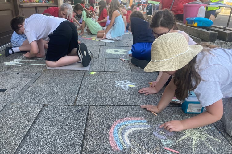 Heads down for an army of young artists creating a chalk gallery of pictures on Tavistock high street for the Lions Carnival Week pavement art competition.