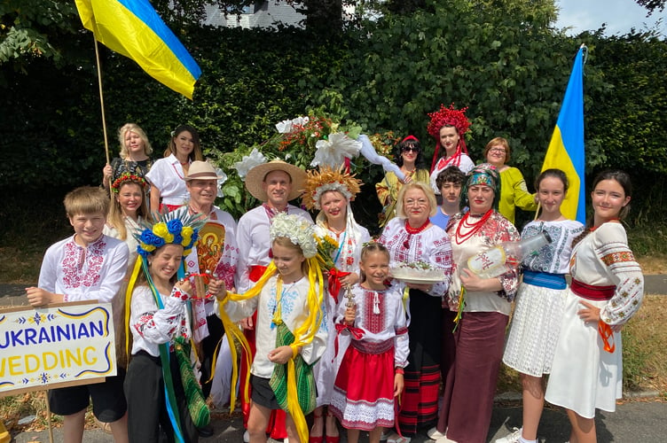 A Ukrainian traditional wedding drew cheers at Tavistock Carnival parade, which was deluged by a brief rainstorm.