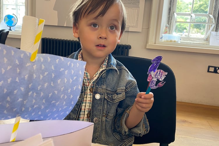 Brian, 3, with the boat and puppet he made at a pirate-themed heritage children's activity session in Tavistock Guildhall.