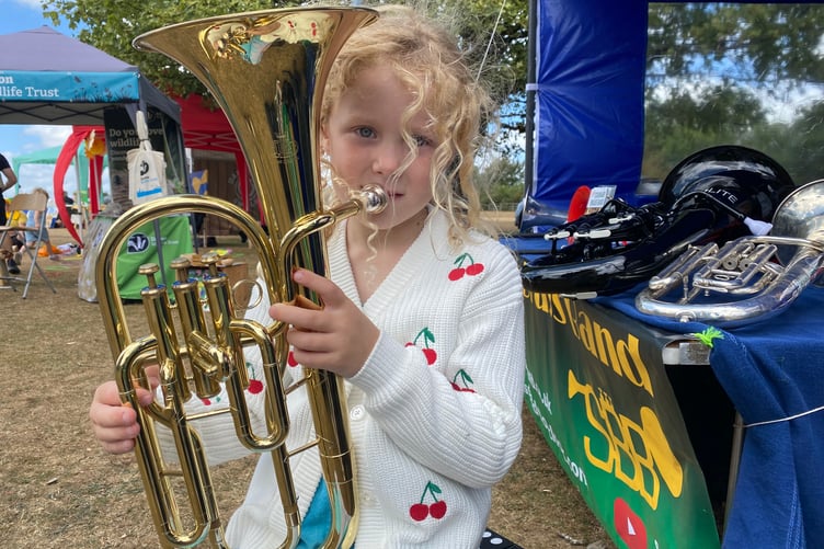 Maisie, 5, takes a blow on the Euphonium with Tavistock's Stannary Brass Band at Yelverton Rotary Club Family Fun Day.