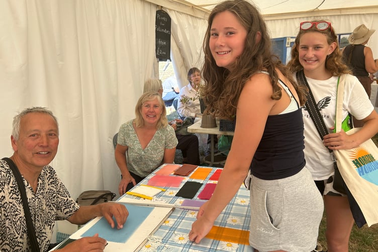 Koy and Hilary Thonson of Okehampton Beekeepers, helping Tilly Turner and Georgina Griffiths, both 13, make beeswax candles.