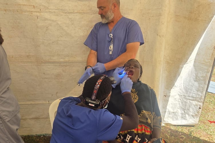 Lee Spencer back, of Horrabridge, helping a dentist with a patient during a charity village dental clinic in Uganda.