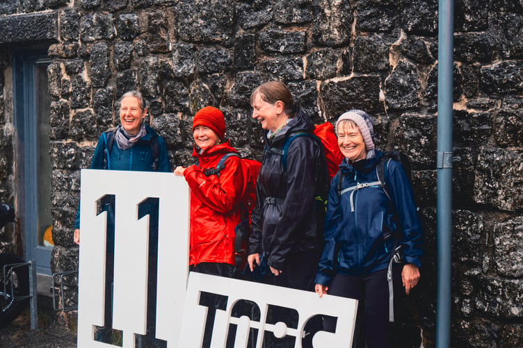Happy walkers celebrate finishing the 11 Tors trek on the moor in aid of Dartmoor Search & Rescue Team Tavistock. Picture by Matt Caine.