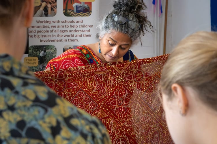 Visitors to Tavistock Respect Festival admire colourful Indian fabrics.