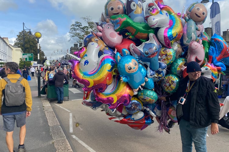 A helium balloon seller making a colourful splash at Tavistock Goose Fair.