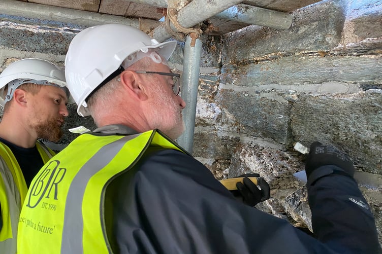A Tavistock local is given a stonework mortaring lesson on Betsy Grimbal Tower which is being restored.